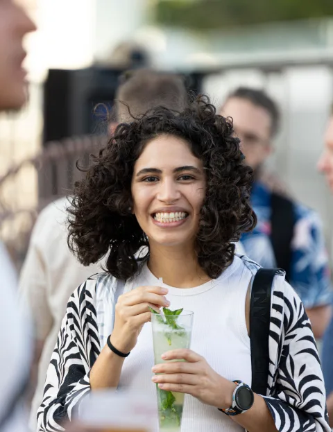Gabriela smiling among other attendees at React Miami 2025.